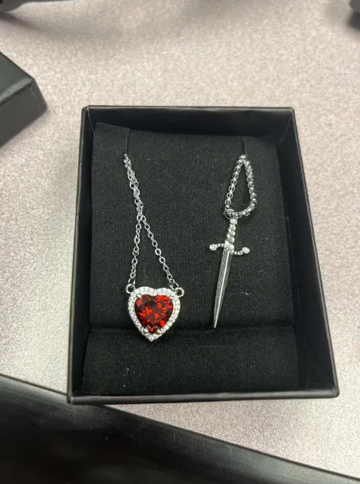 Colar Duplo de Casal ✨ Espada e coração simbolizam proteção e amor eterno. Em aço inoxidável e zircônia, é o presente perfeito para celebrar a união!