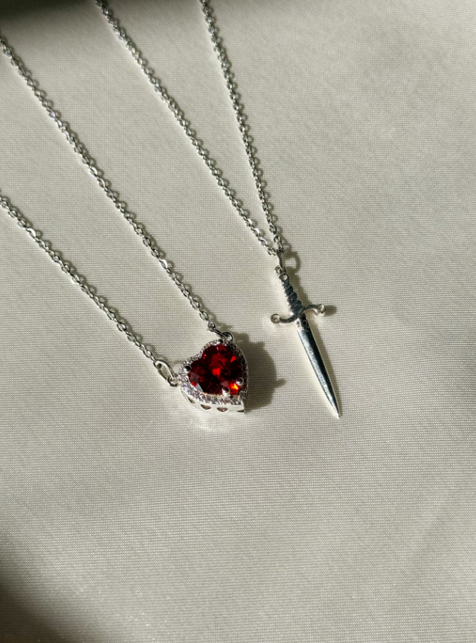 Colar Duplo de Casal ✨ Espada e coração simbolizam proteção e amor eterno. Em aço inoxidável e zircônia, é o presente perfeito para celebrar a união!
